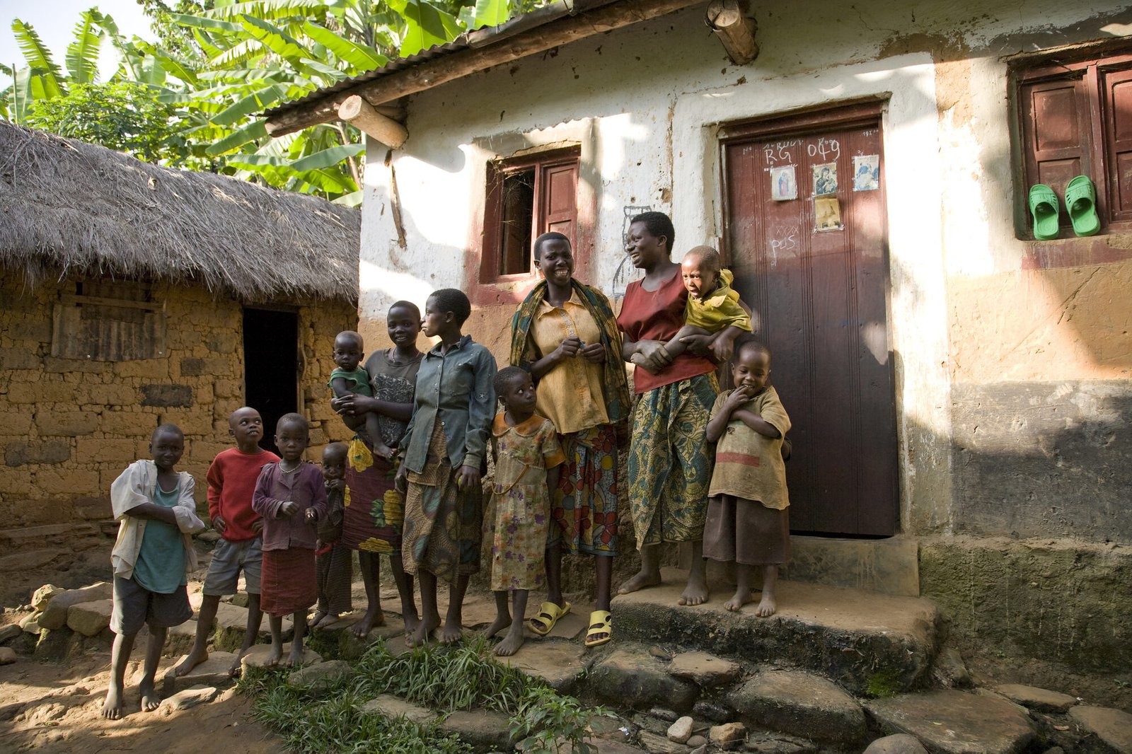 Família i infants davant d'una llar rural a Gàmbia